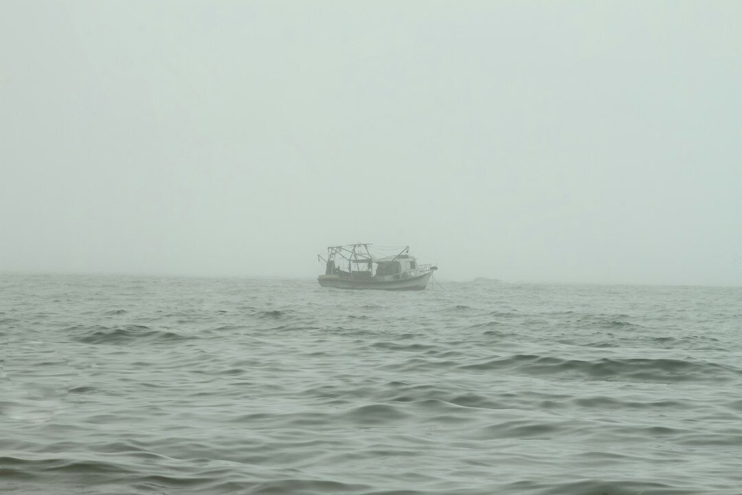 fisherman on boat in fog