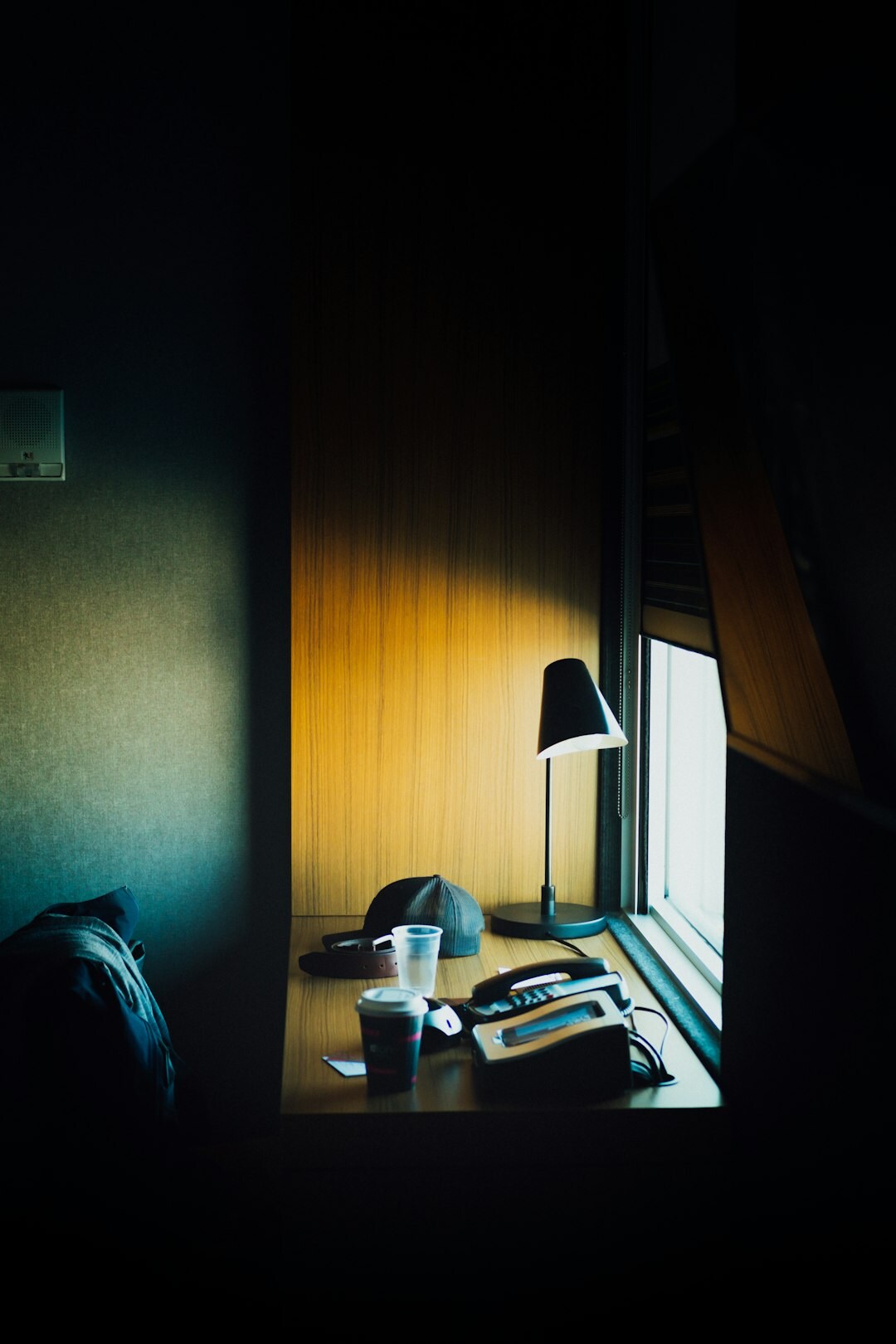 Small editorial office desk with a laptop, notebook and a cup of coffee by a window